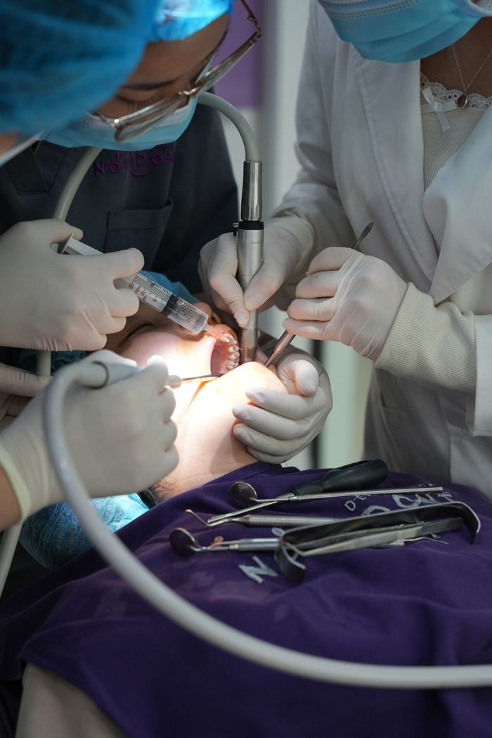 services-01 Close-up of a dental surgery with a team of medical professionals working together.